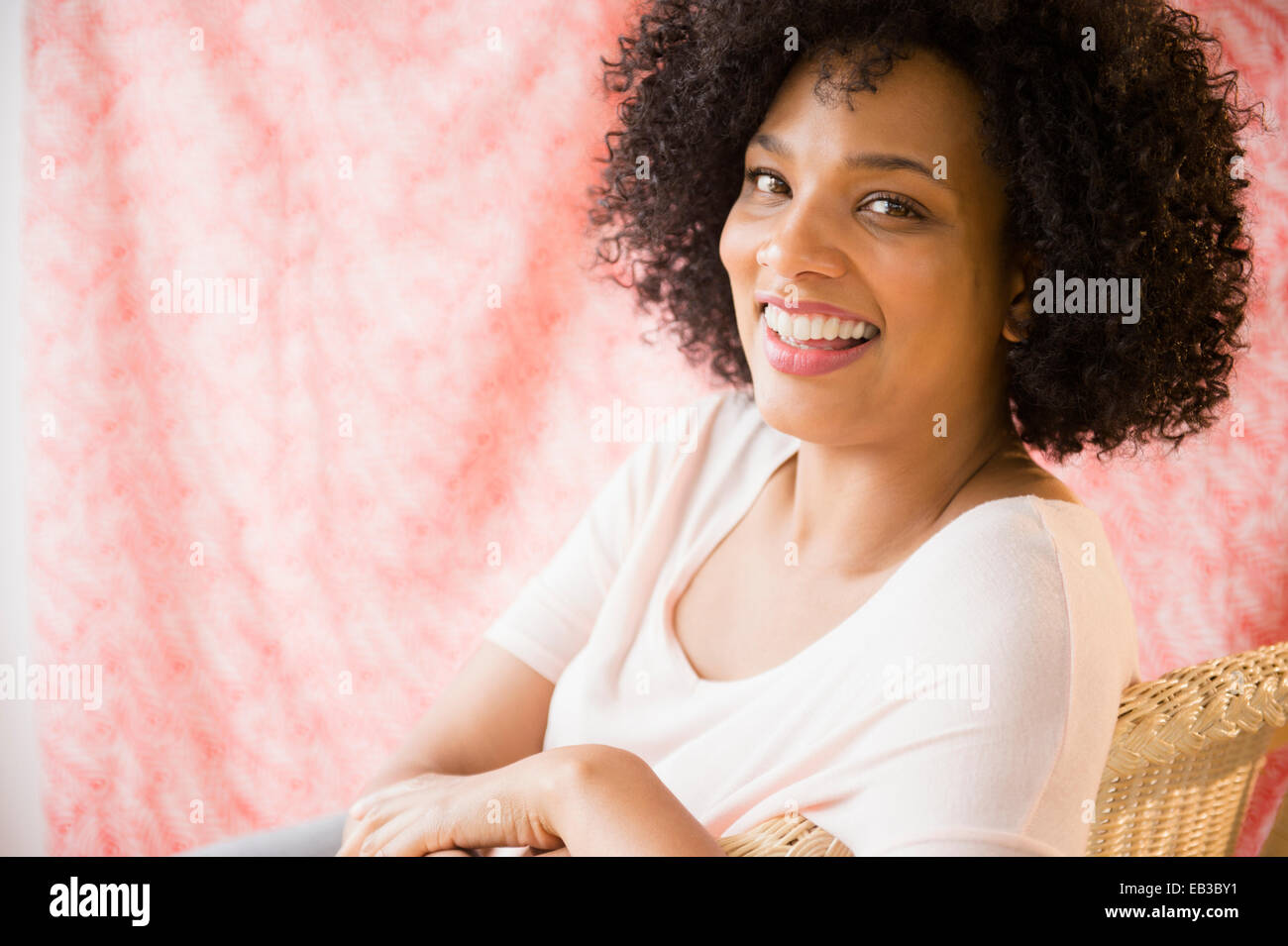 Lächelnde Frau sitzen auf Stuhl Stockfoto