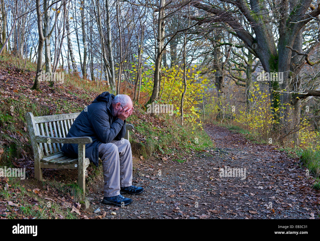 Senior Mann sitzt auf der Bank, mit Kopf in Händen Stockfoto