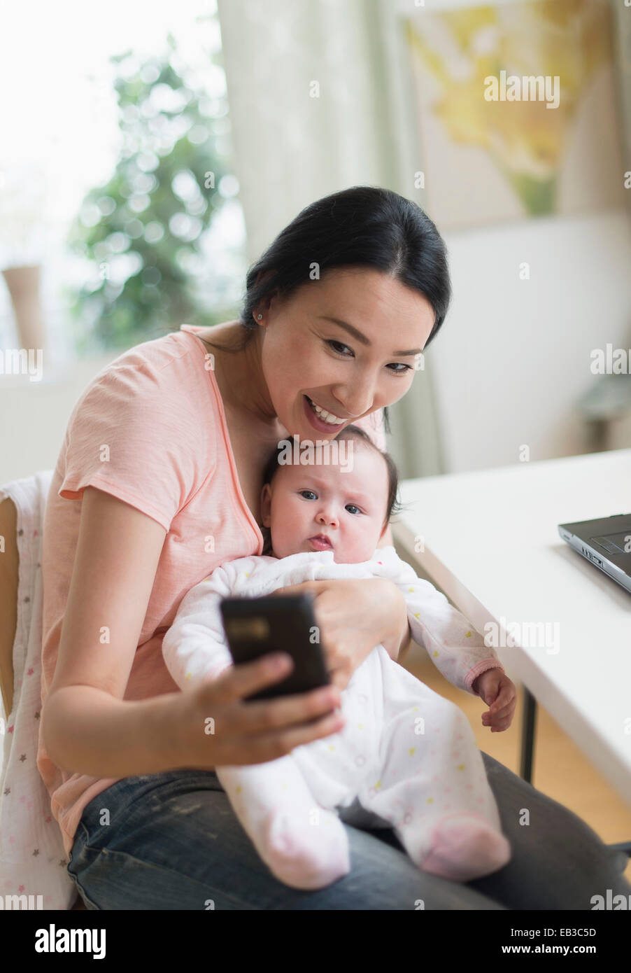 Asiatische Mutter und Baby nehmen Selfie im home-office Stockfoto