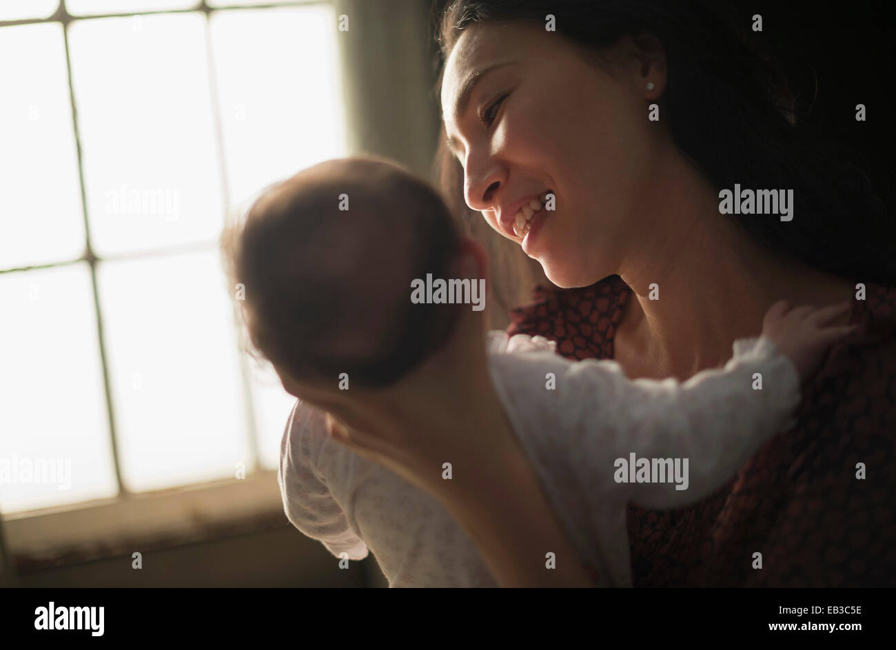 Asiatische Mutter halten Baby in der Nähe von Fenster Stockfoto