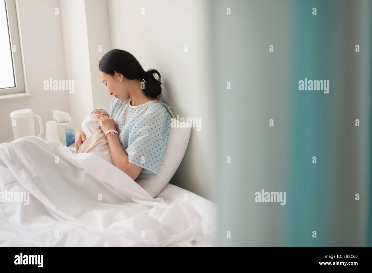 Asiatische Mutter Holding neugeborenes Baby im Krankenhaus Stockfoto