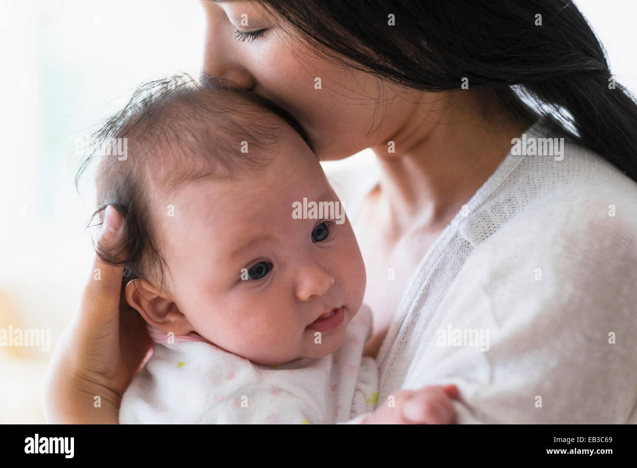 Asiatische Mutter halten und küssen baby Stockfoto