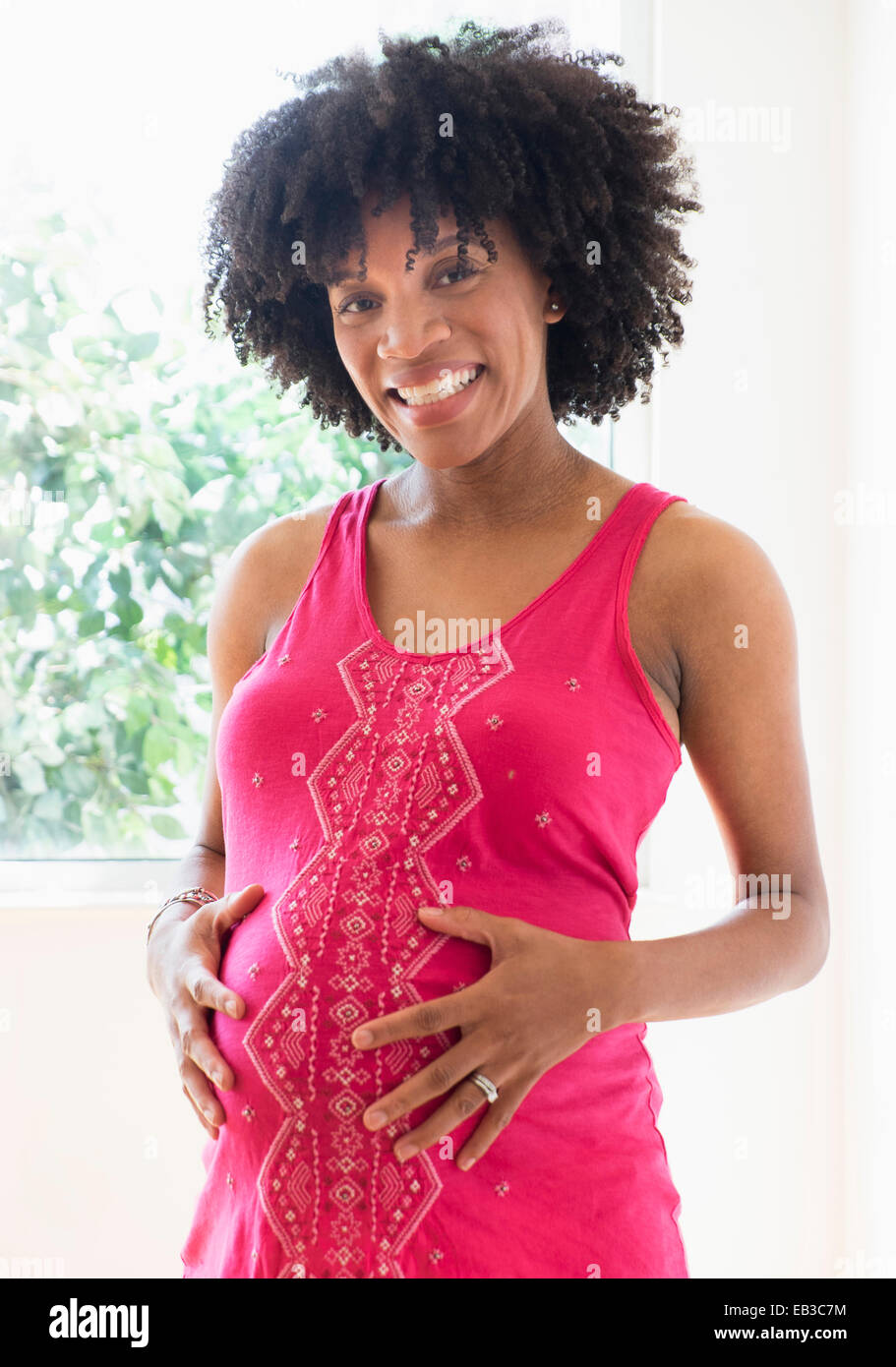 Schwanger African American Mutter hält Magen Stockfoto