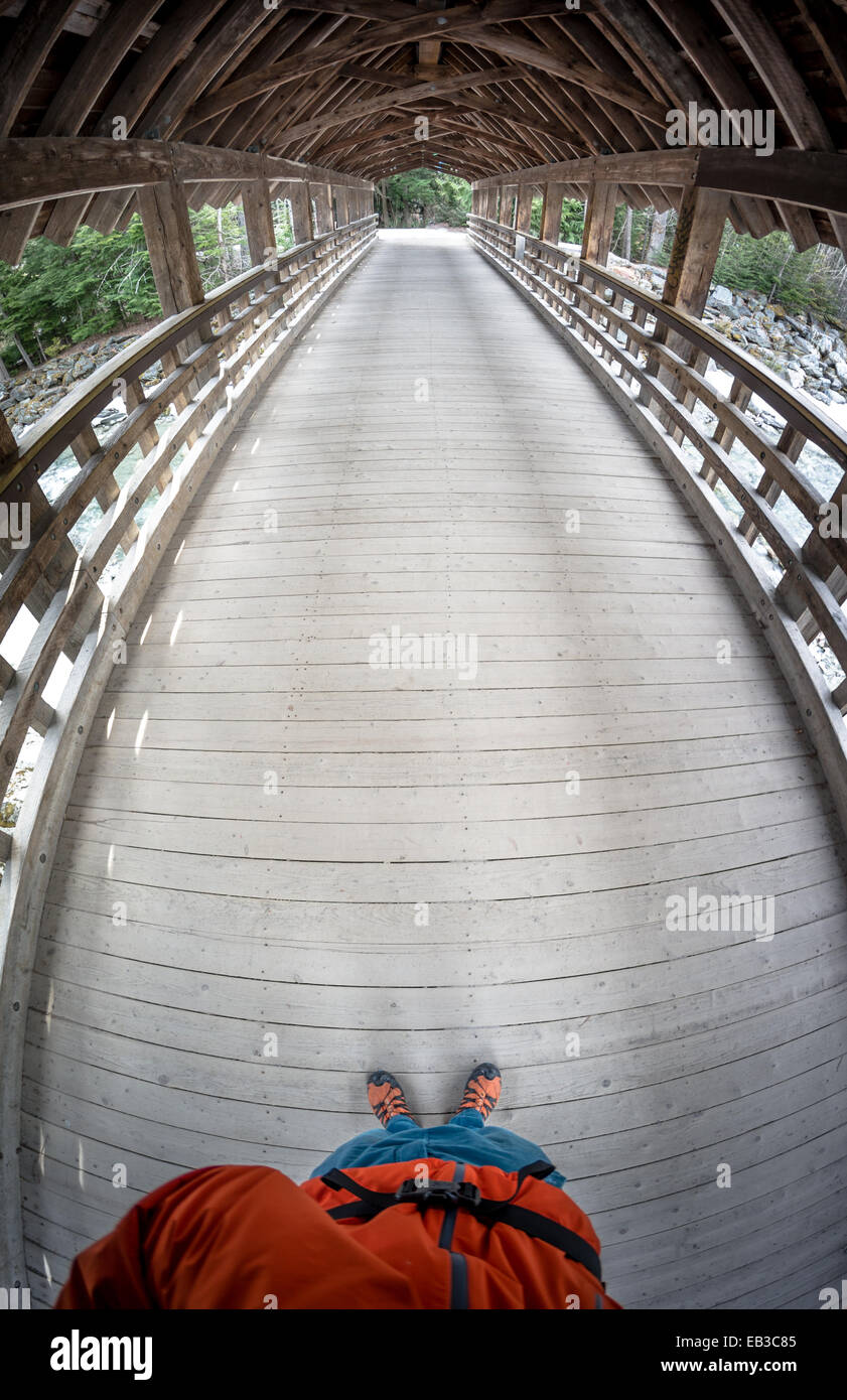 Mann, der auf einer Holzbrücke steht und ein Foto macht, Whistler, British Columbia, Kanada Stockfoto