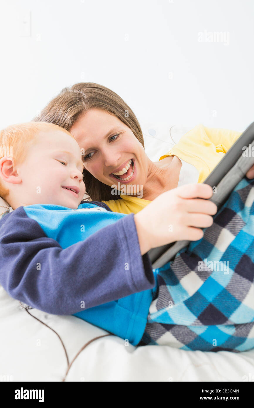 Kaukasische Mutter und Sohn mit digital-Tablette im Bett Stockfoto