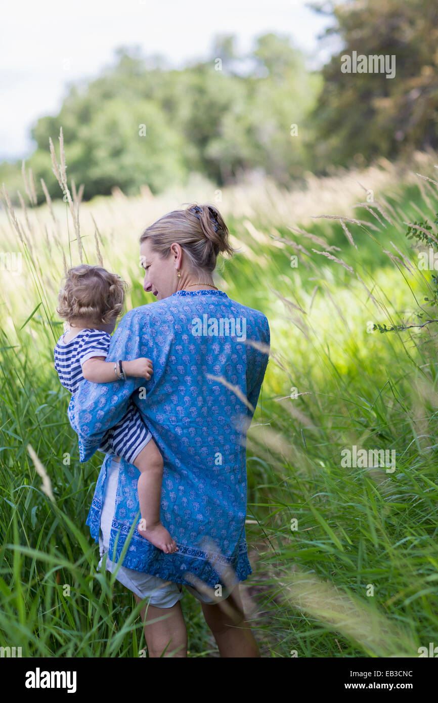 Kaukasische Mutter mit Baby Sohn auf Wiese Stockfoto