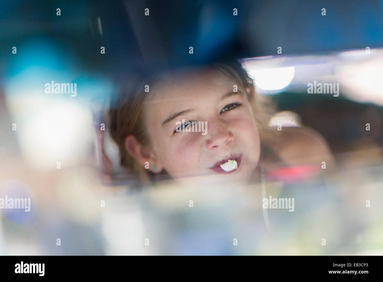 Reflexion des kaukasischen Mädchens Bubble Gum Seifenblase im Rückspiegel Stockfoto