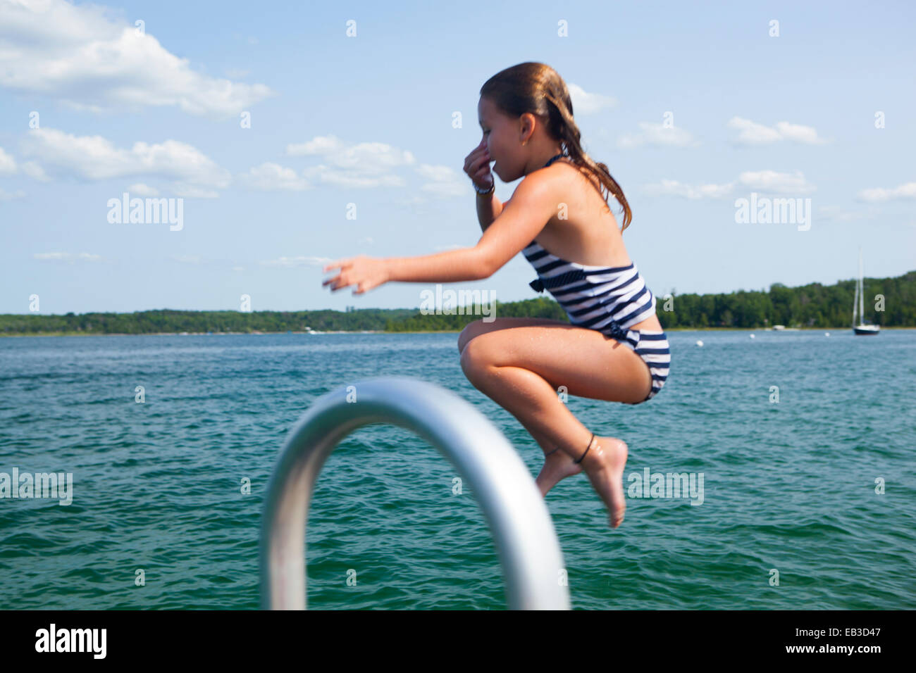 Kaukasische Mädchen springen in See Stockfoto