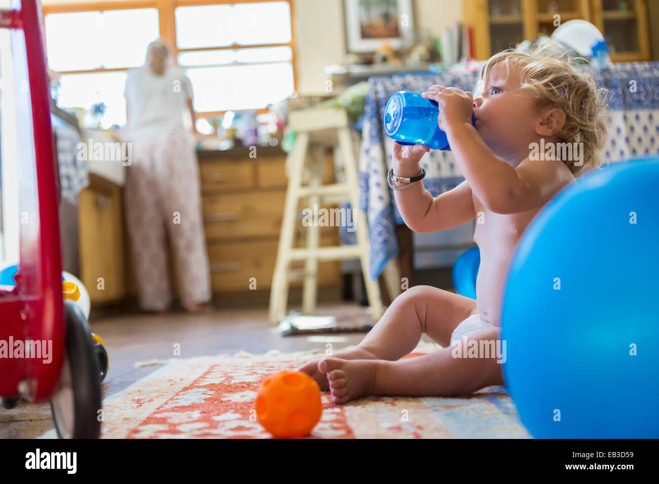 Kaukasische Baby Boy Trinkwasser in Küche Stockfoto