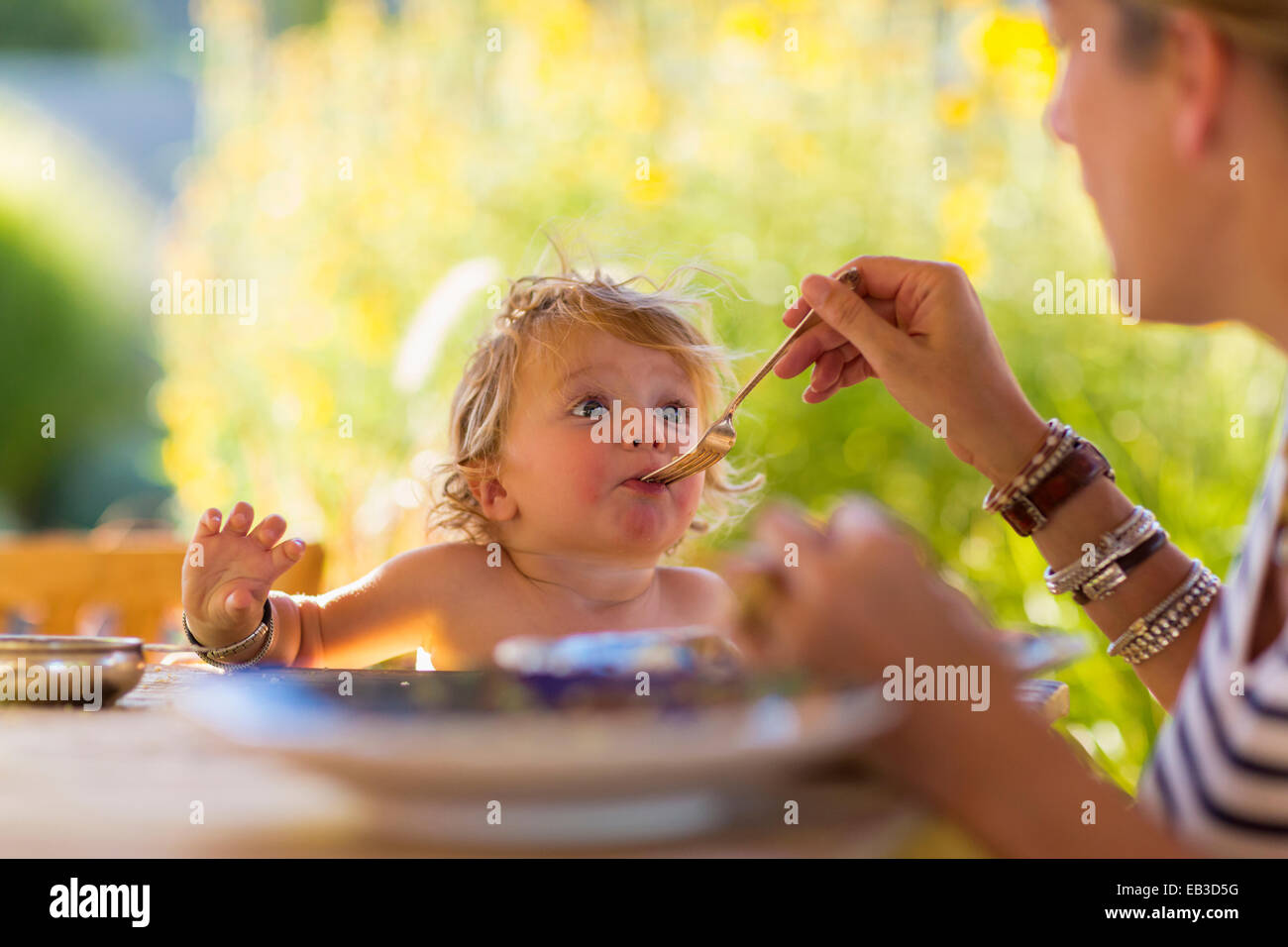Kaukasische Mutter füttert Baby Sohn am Tisch Stockfoto