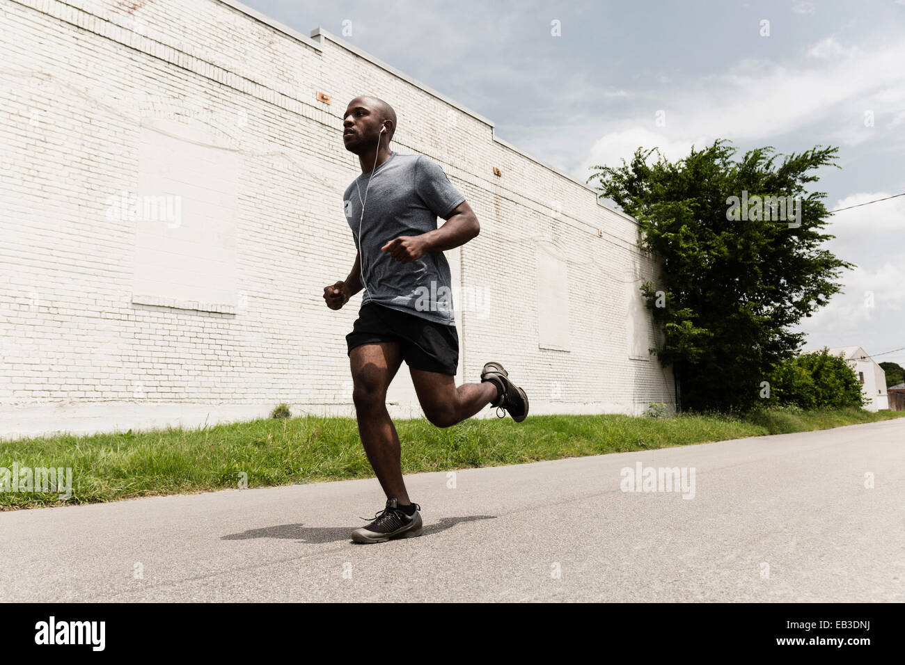 Schwarzer Mann läuft auf Stadtstraße Stockfoto