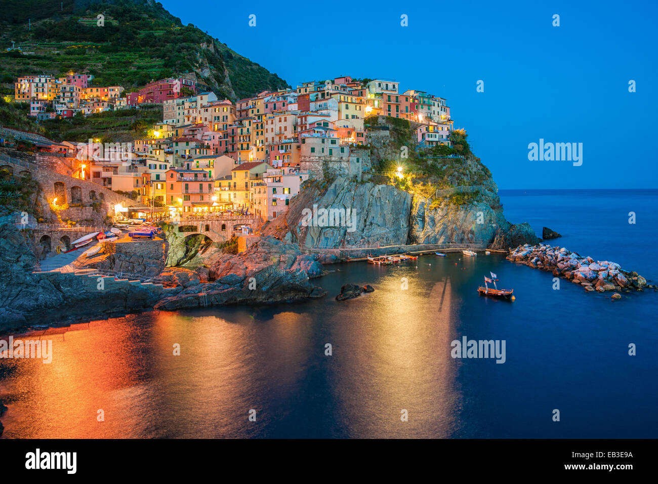 Italien, Ligurien, La Spezia, Cinque Terre, Manarola, Stadt in der Abenddämmerung mit elektrischem Licht Stockfoto