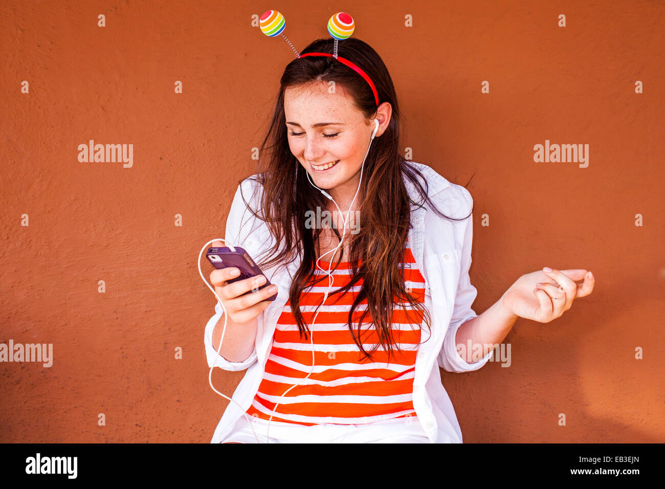 Kaukasischen Frau in Neuheit Antenne anhören von MP3-player Stockfoto