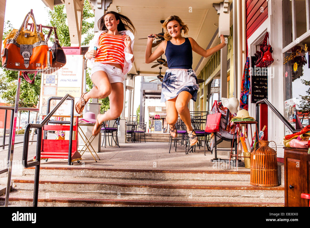 Kaukasische Mädchen im Teenageralter springen vor Freude in die Stadt Stockfoto