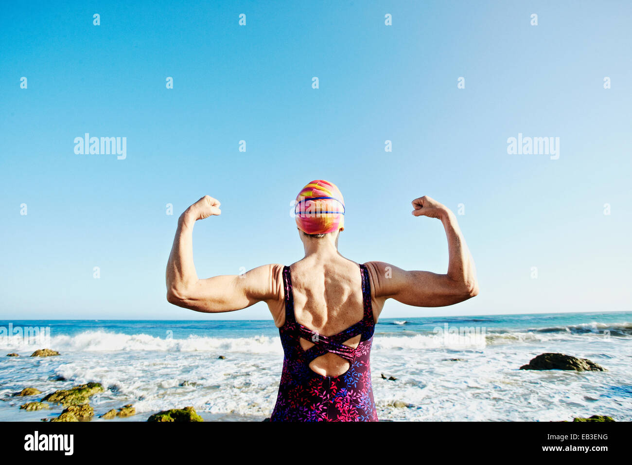 Ältere Frau kaukasischen ihre Muskeln am Strand Stockfoto