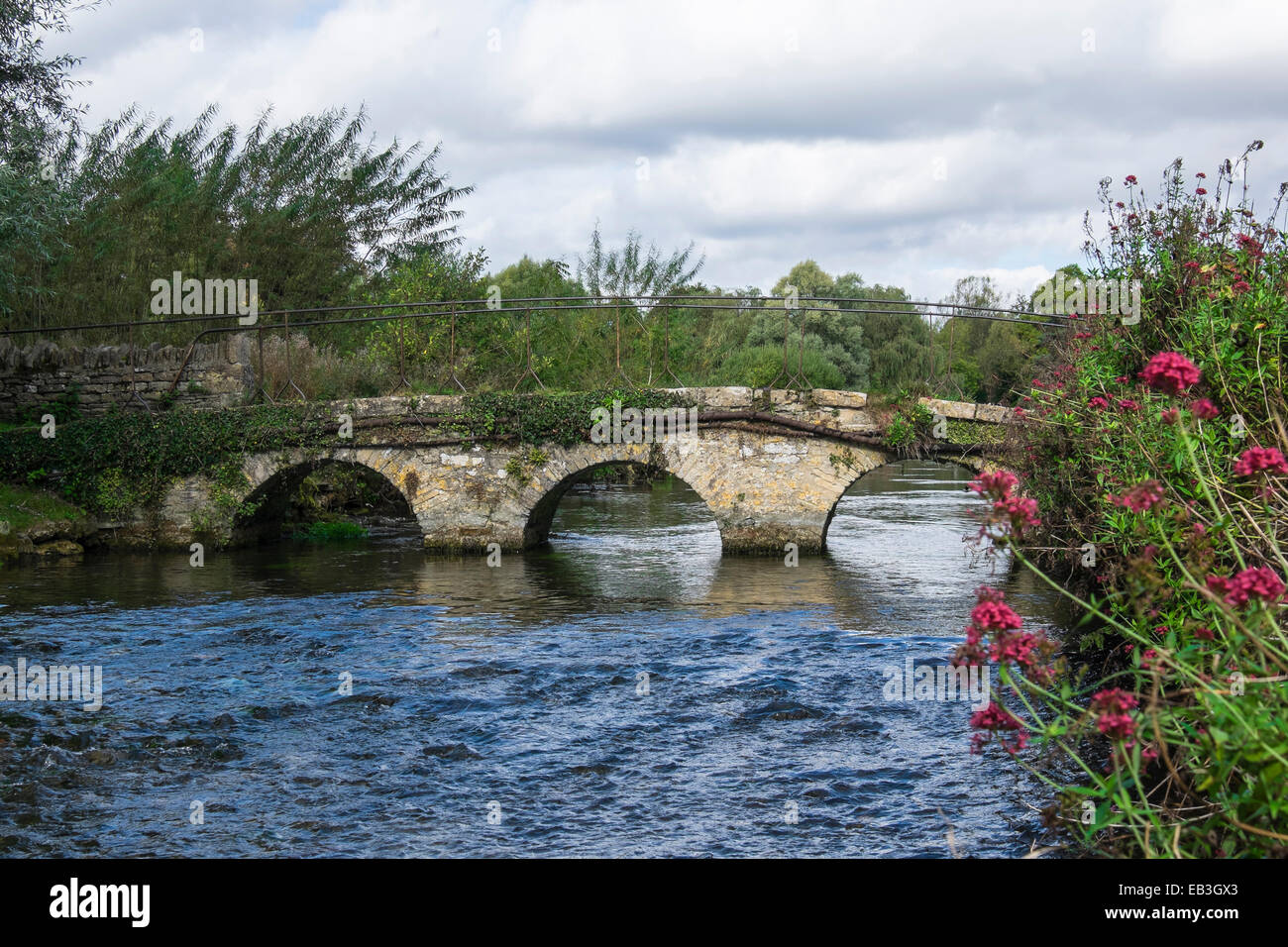 Fußgängerbrücke über den River Coln nach Arlington Row Bibury Gloucestershire, England Stockfoto