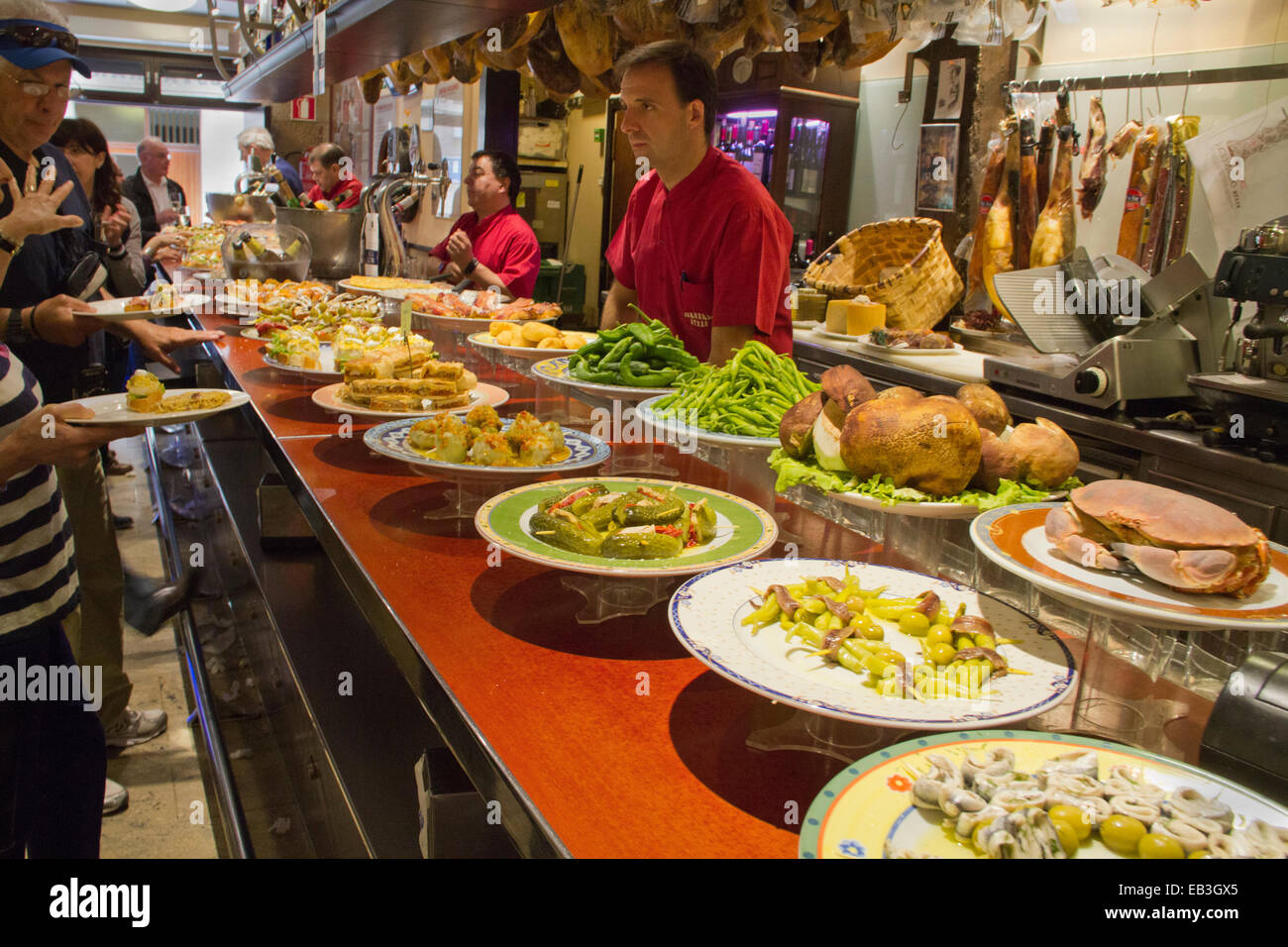 Platten von Tapas (Pintxos auf Baskisch) auf die Bar und die Kunden bestellen was sie wollen, San Sebastian, Spanien Stockfoto