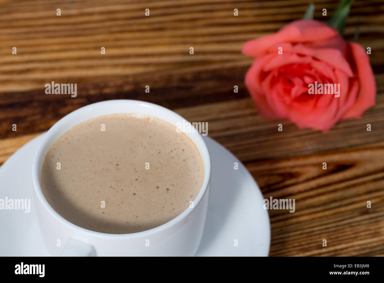 Tassen Kaffee und rosa Rosen auf weißem Hintergrund Stockfoto