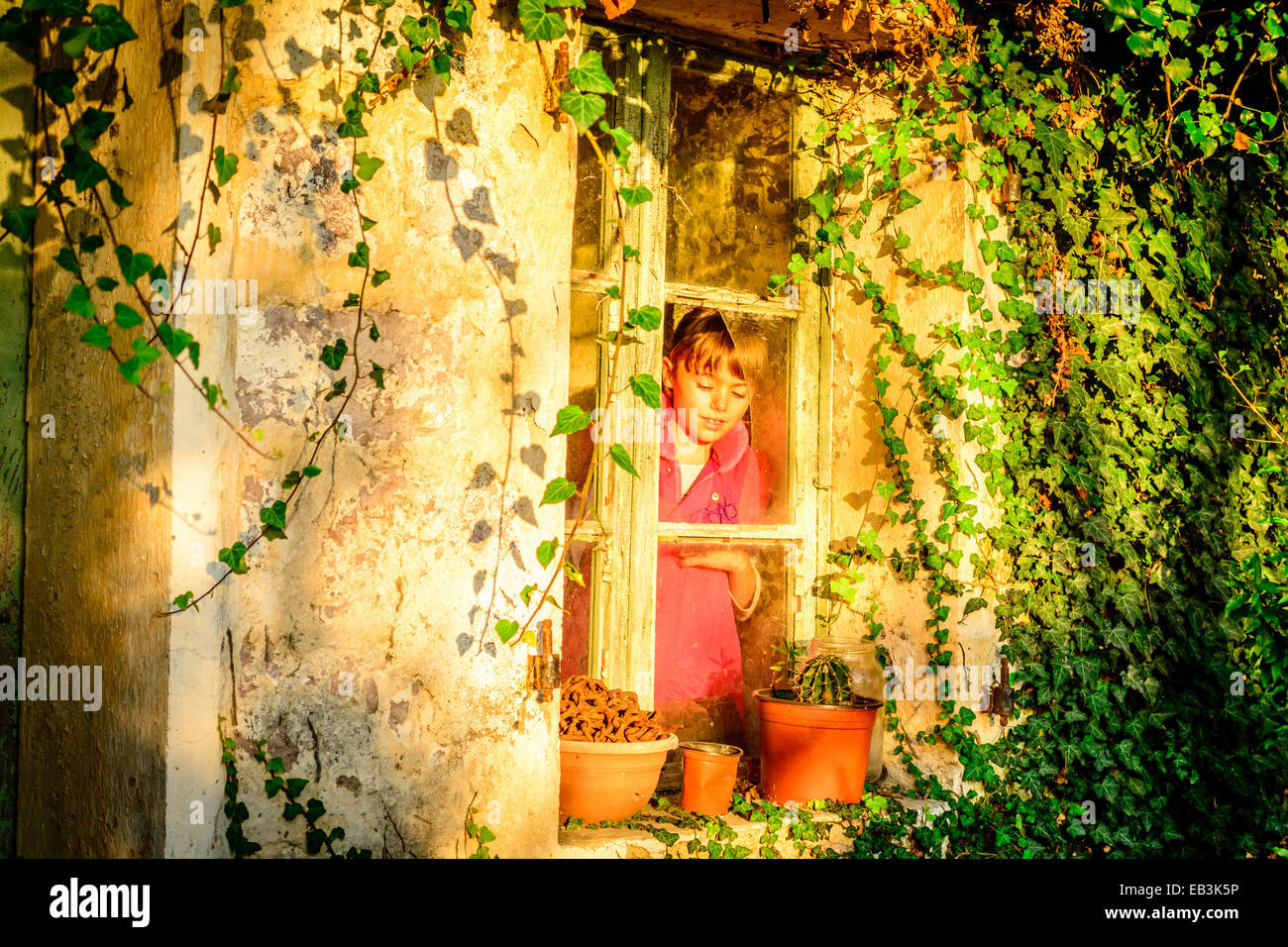 Kleines Mädchen am Fenster stehend Stockfoto