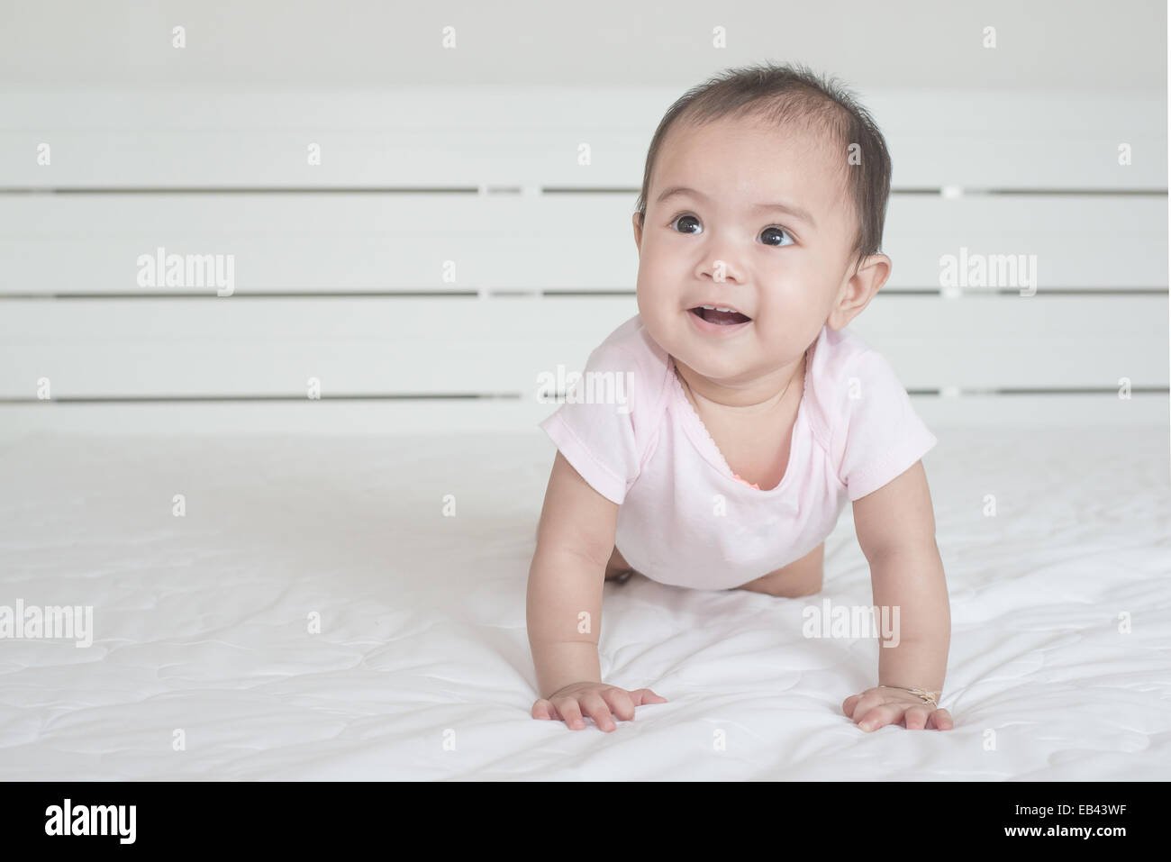 Asiatisches Baby krabbeln im Schlafzimmer Stockfoto