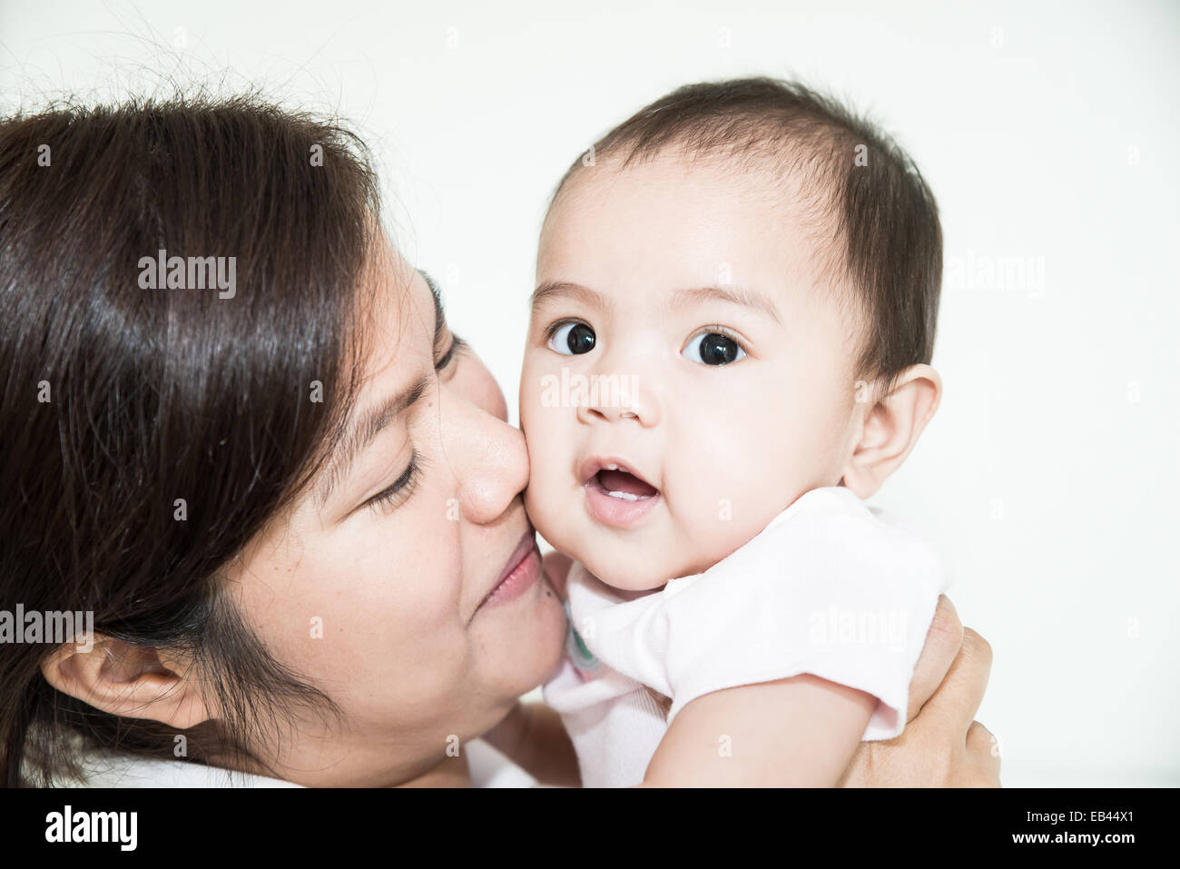 Glückliche Familie fröhlich. Asiatische Mutter und Baby küssen, lachen und umarmen Stockfoto