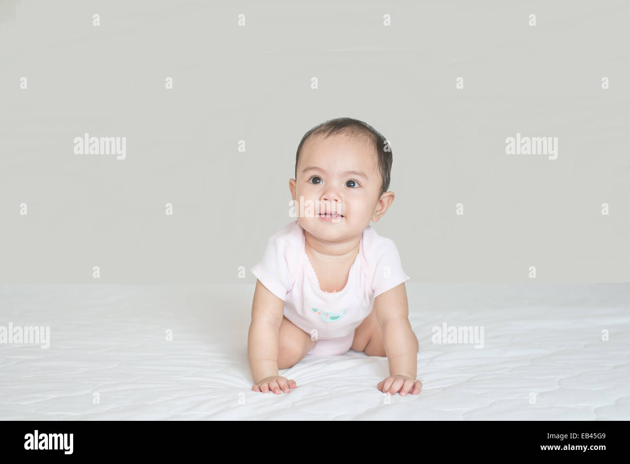 Süße Asiatin Baby krabbeln im Schlafzimmer Stockfoto