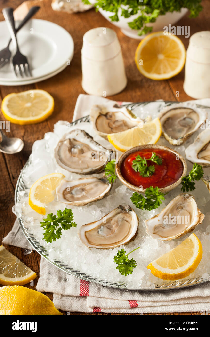 Rohe organische Austern mit Zitrone und Cockatail-Sauce Stockfoto