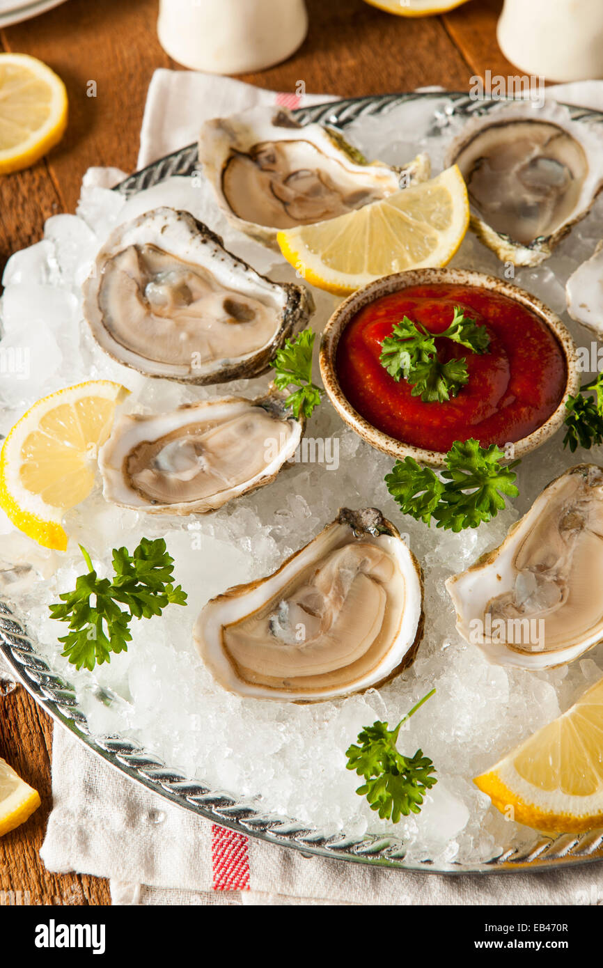 Rohe organische Austern mit Zitrone und Cockatail-Sauce Stockfoto