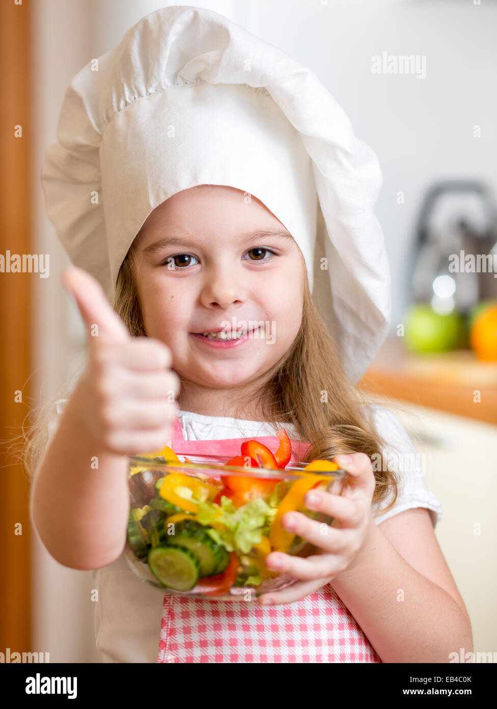 kleines Mädchen gesundes Essen zubereiten und Daumen auftauchen Stockfoto