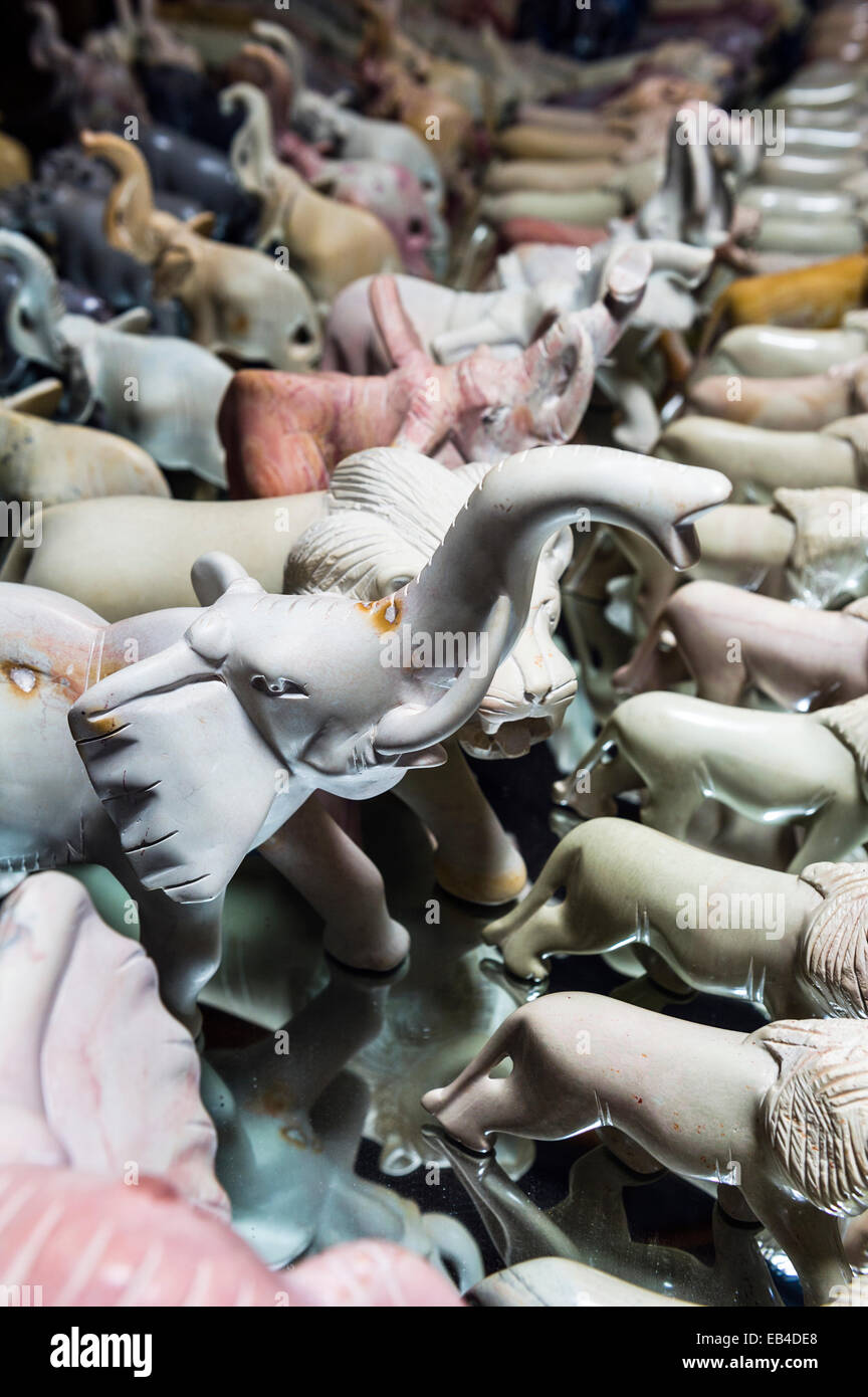 Afrikanische Elefanten, Löwen und andere Tiere aus Speckstein für den Verkauf an Touristen in einem am Straßenrand Stall geschnitzt. Stockfoto