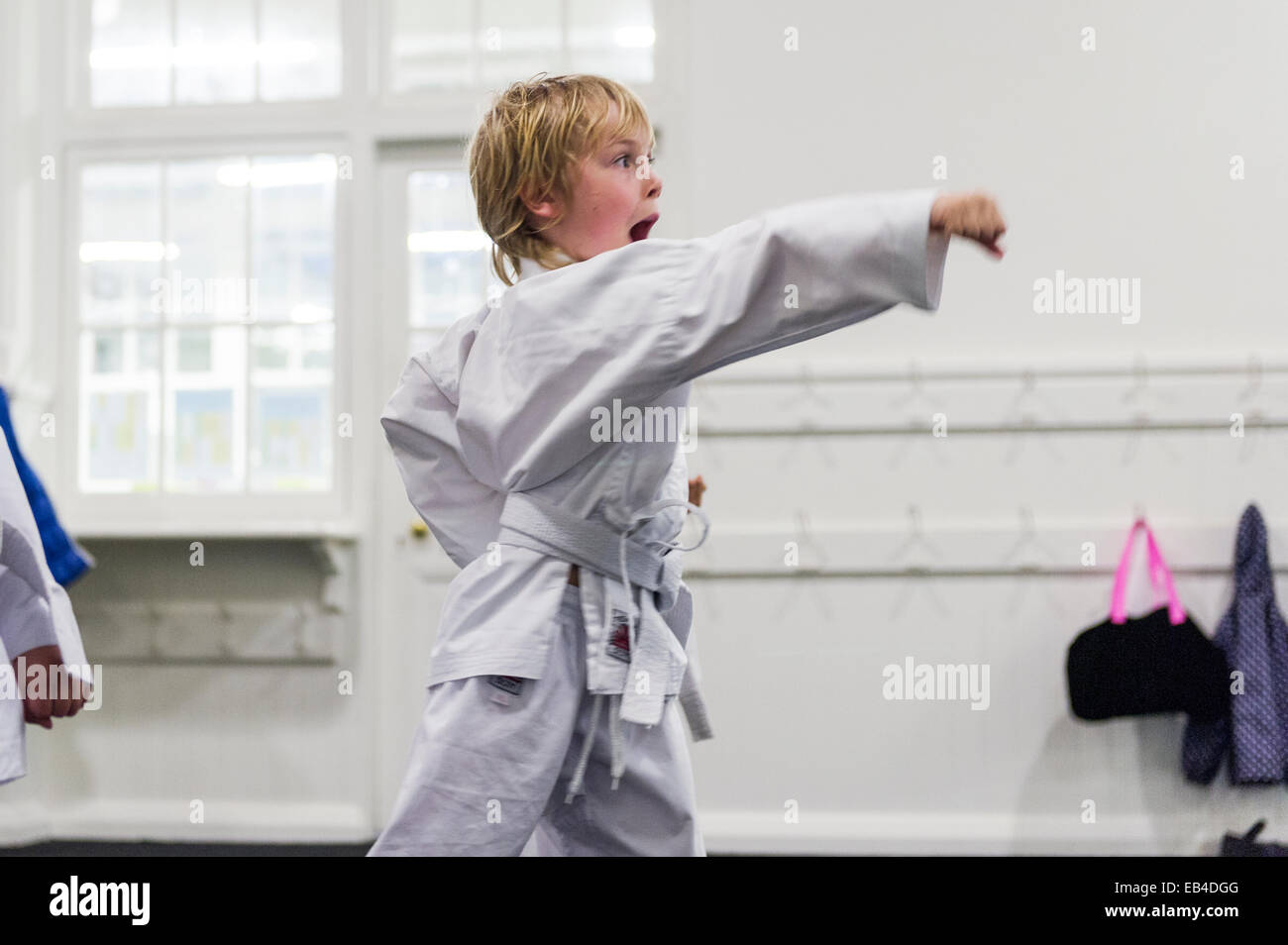 Ein Junge praktiziert eine Stanz Bewegung während des Karate Trainings. Stockfoto