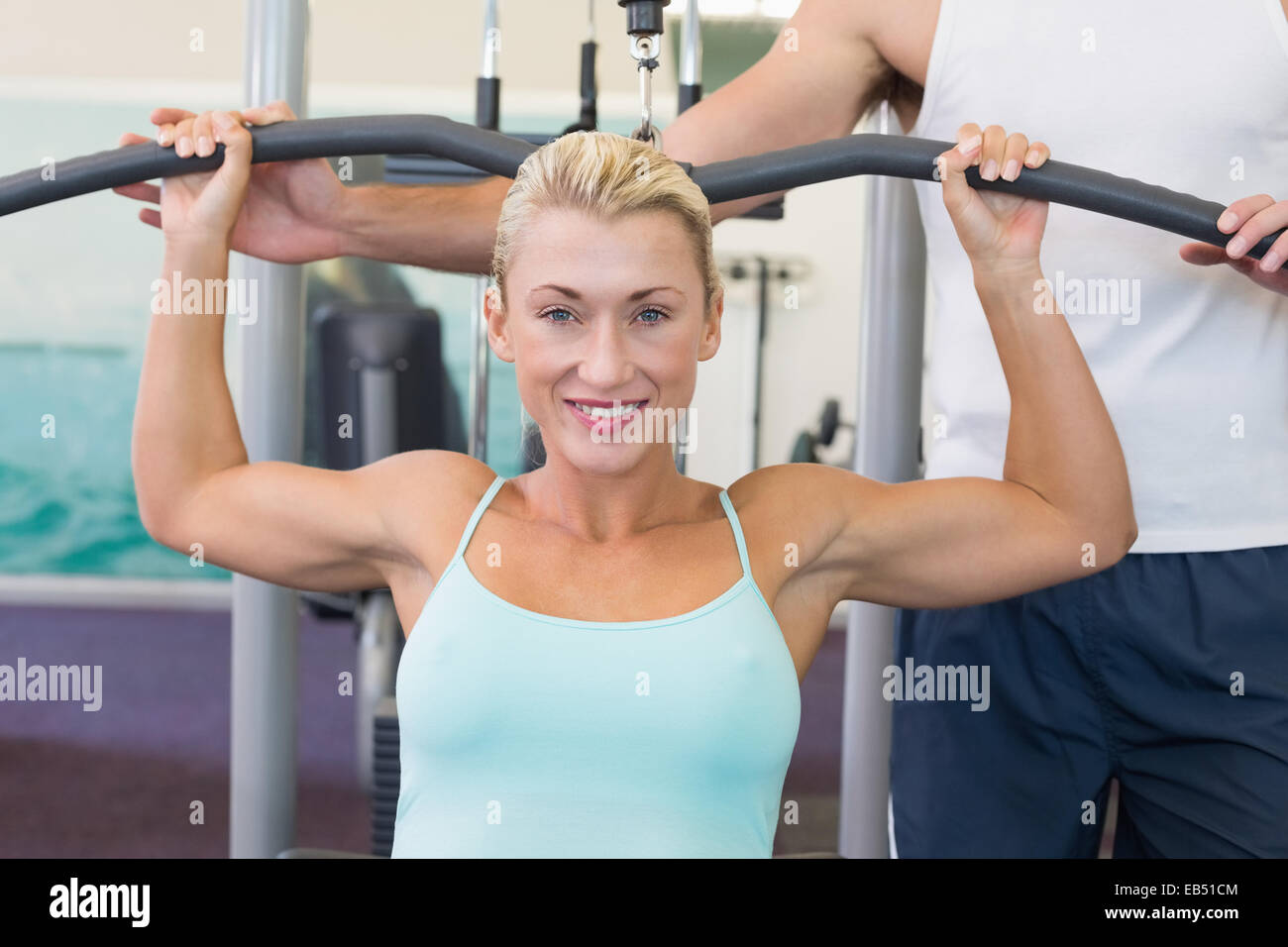 Schöne Frau, die auf einer Lat-Maschine im Fitness-Studio trainieren Stockfoto