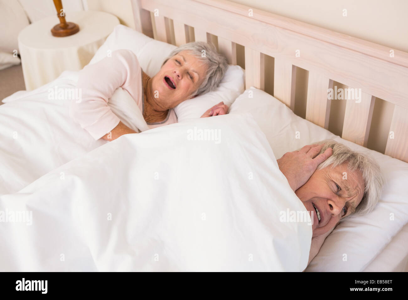 Senior woman seine Ehefrauen Schnarchen Ausblocken Stockfoto