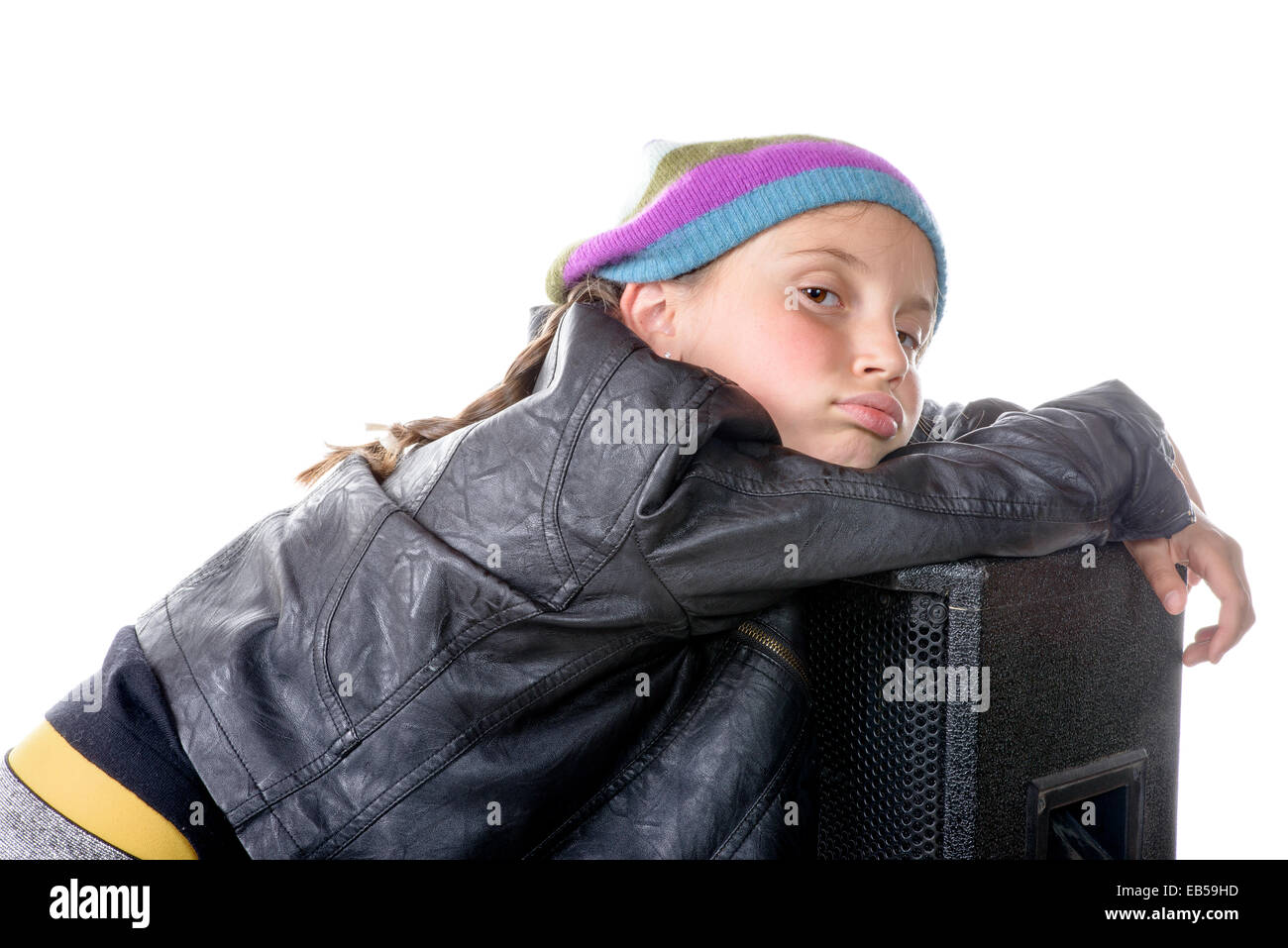 ein kleines Mädchen sitzt auf einem Lautsprecher auf weißem Hintergrund Stockfoto
