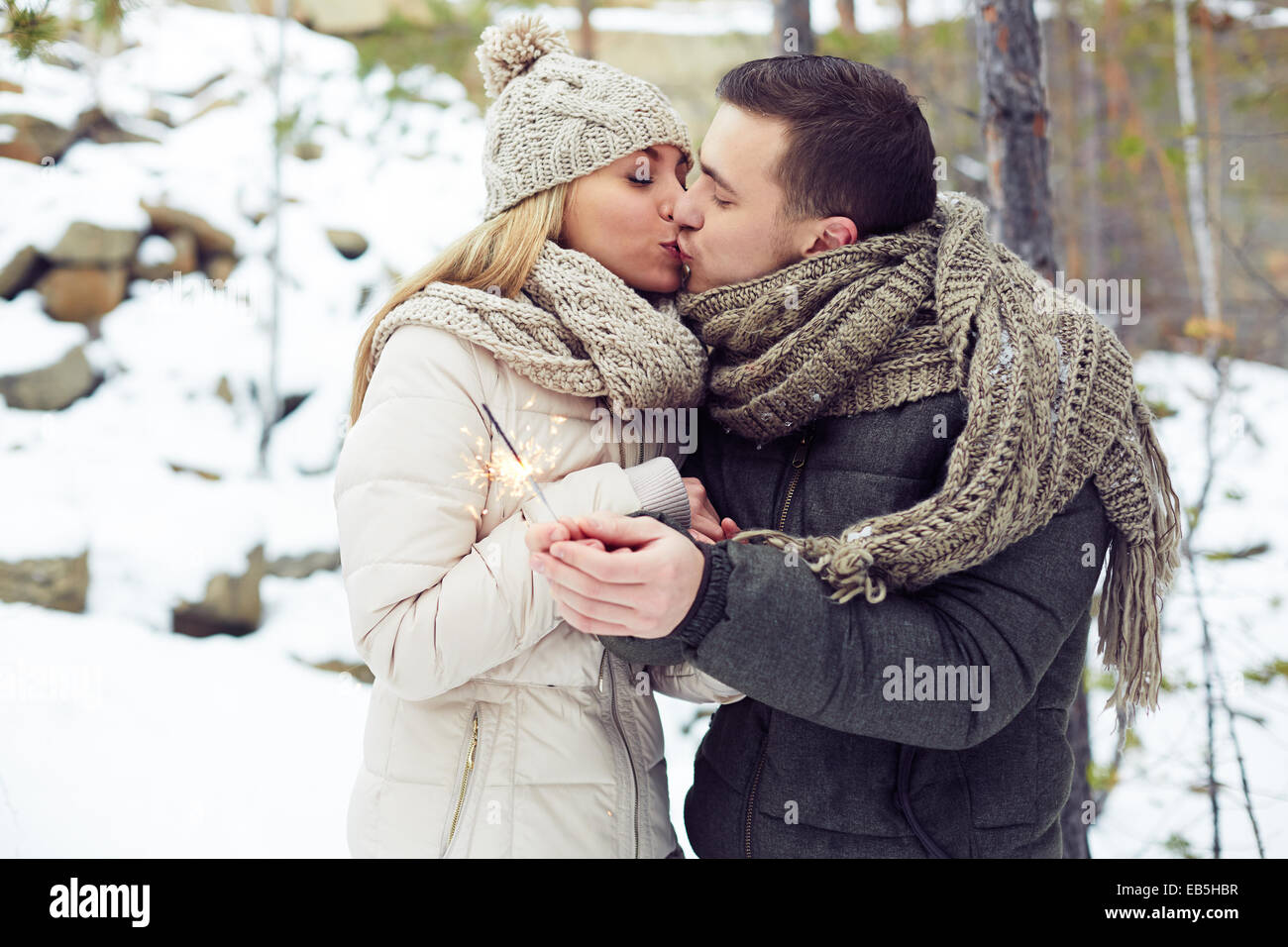 Junge Paar küssen im Winterwald Stockfoto