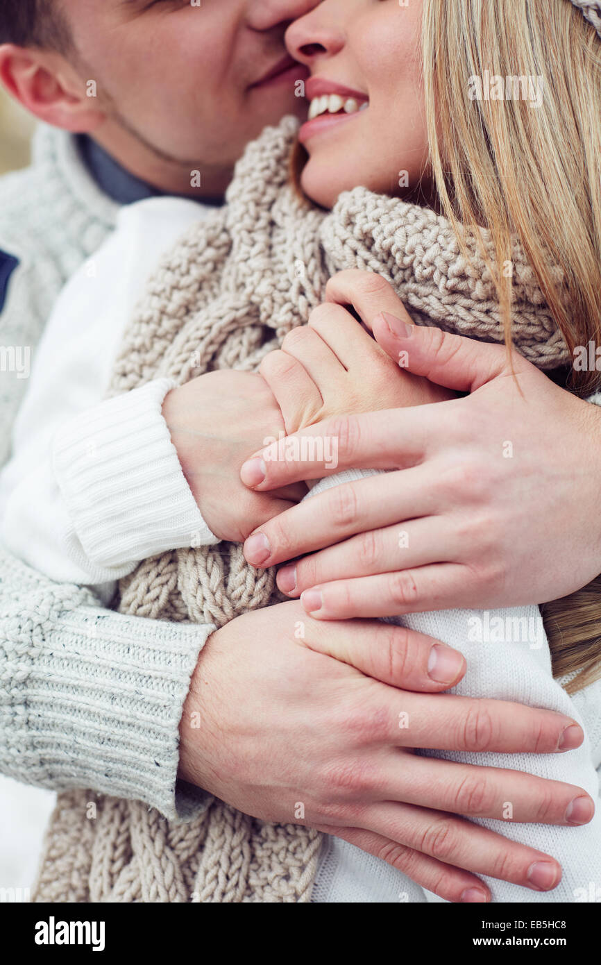Junges Paar in Pullover umarmen und küssen im freien Stockfoto