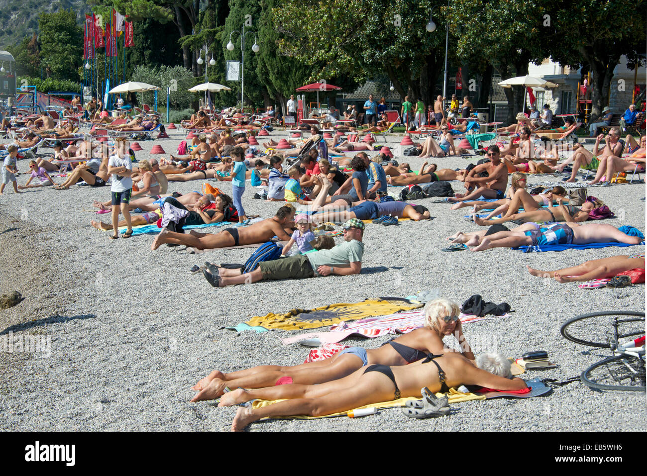 Menschen, die zum Sonnenbaden Torbola Strand am Gardasee Italien Stockfoto