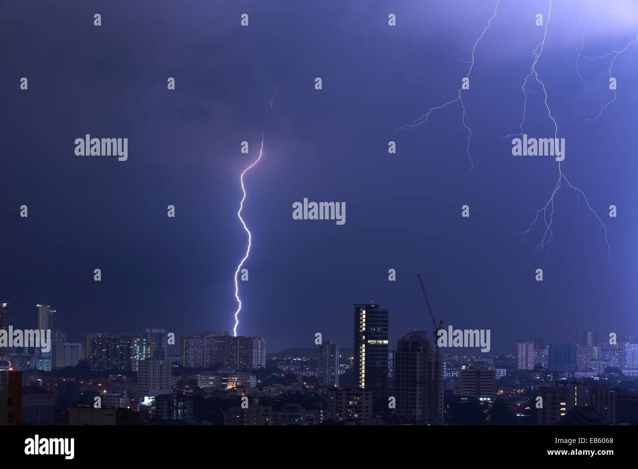 Beeindruckende Blitz Blitz über eine schlafende Stadt. Wichtigsten Streik schlagen ein hohes Gebäude mit sekundären Gabeln füllen das Bild. Stockfoto
