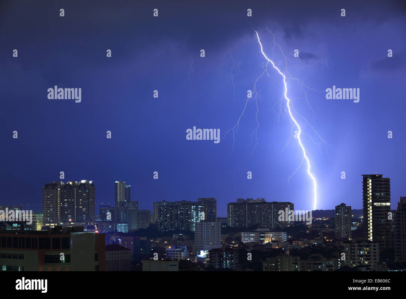 Beeindruckende Blitz Blitz über eine schlafende Stadt. Hellen Blitz, rechts der Schuss, mit einem sichtbaren Boden jenseits der Stadt schlagen. Stockfoto