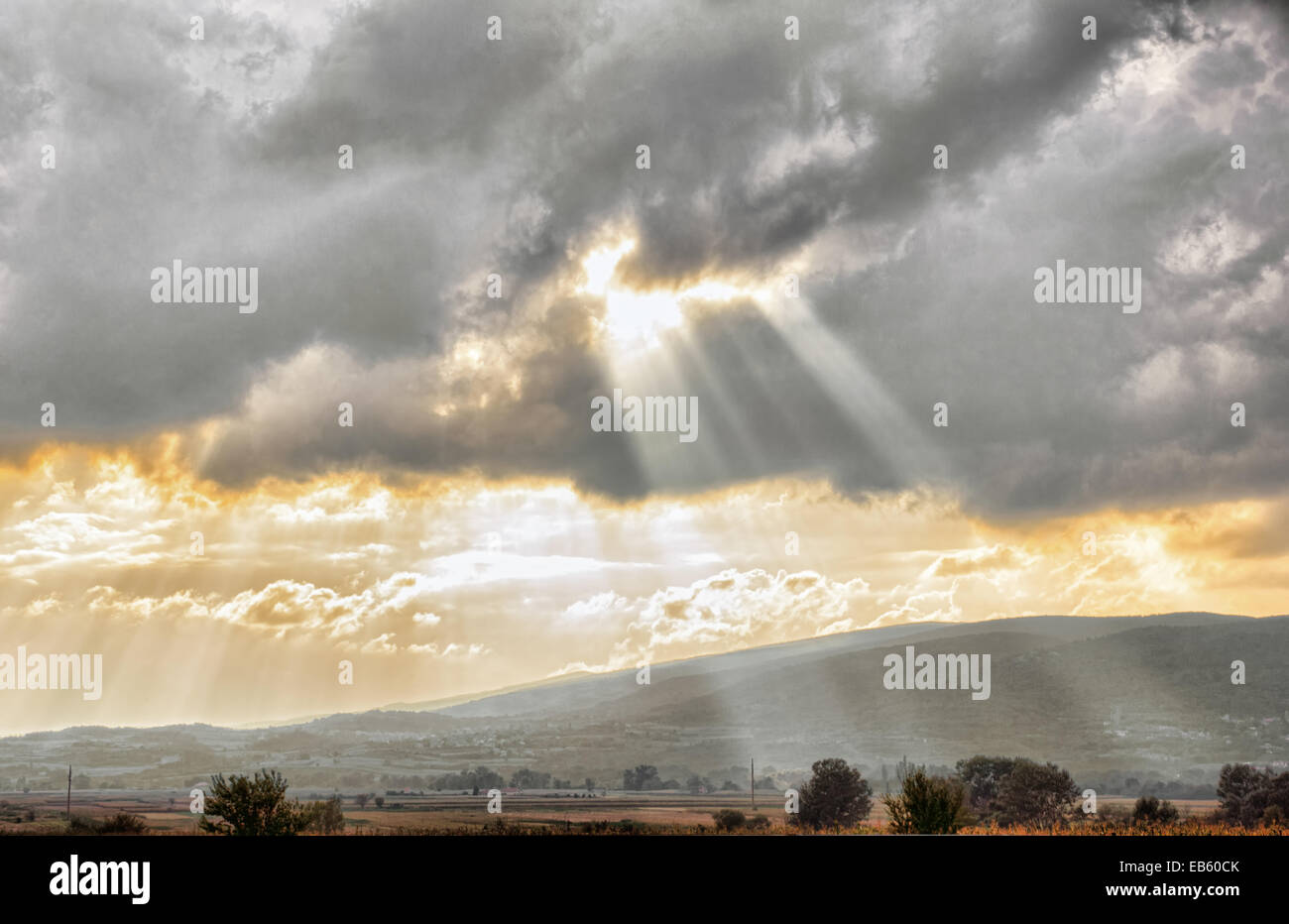 Goldener Sonnenuntergang durch Wolken über dramatische Himmel Landschaftskonzept, Amazing Sonnenuntergang Sonne und Wolken über Landschaft, Sonnenstrahlen sh Stockfoto