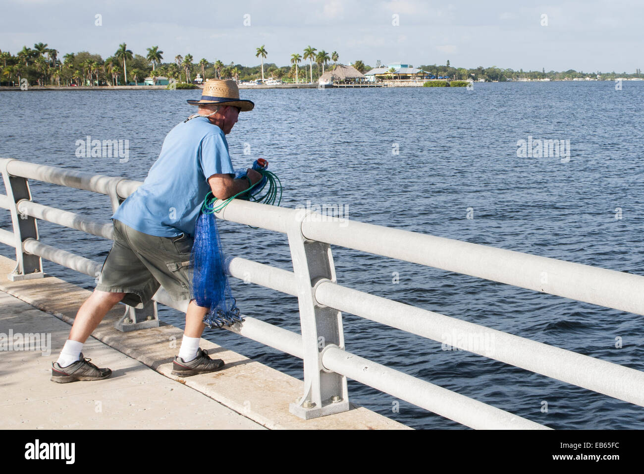 Mann stand auf der Manatee River Riverwalk mit einer Besetzung net Suchen in den Fluss. Stockfoto