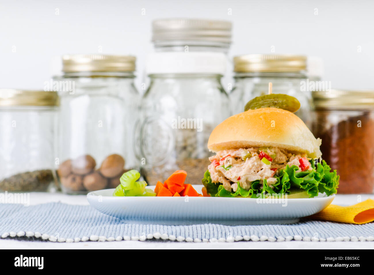 Thunfisch-Salat-Sandwich mit Salat auf einem hausgemachten Brötchen mit gesunden Karotten und Sellerie-Sticks und eine Gurke Stockfoto