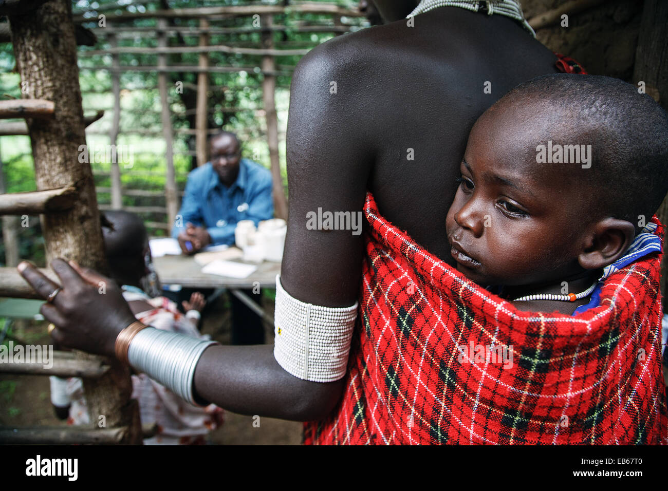 Ein Massai (Masai) Frau mit einem Kind darauf warten, einen Arzt in einer ländlichen Klinik in abgelegenen Teil von Nord-Tansania, Afrika. Stockfoto