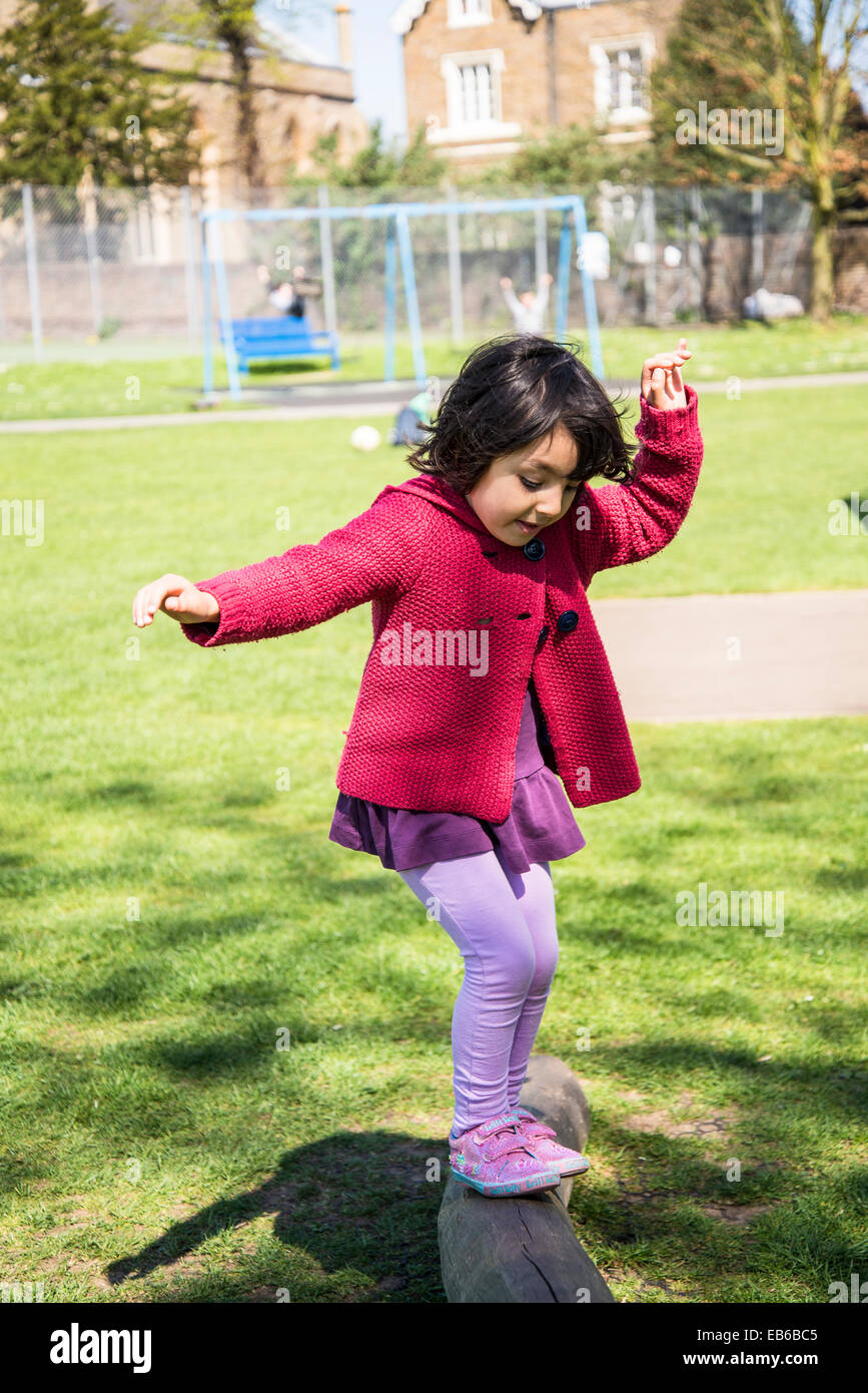 Fünf Jahre altes Mädchen, die versuchen, ihr Gleichgewicht zu halten auf einem Balken im Kinderspielplatz Stockfoto