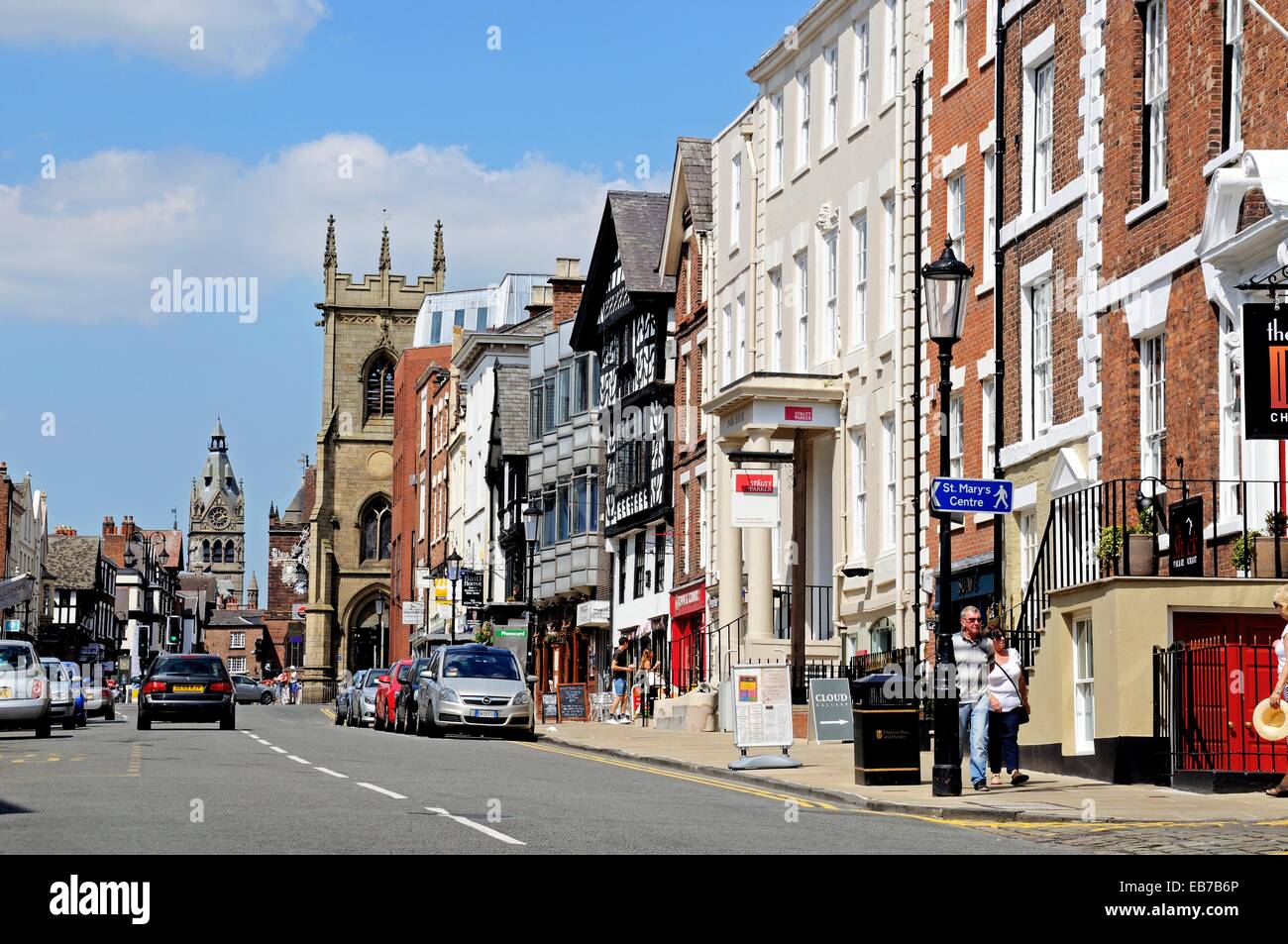 Gebäude und Geschäfte entlang der Bridge Street mit St. Peterskirche und St.-Michaels-Kirche an der Rückseite, Chester, Cheshire, England, UK Stockfoto