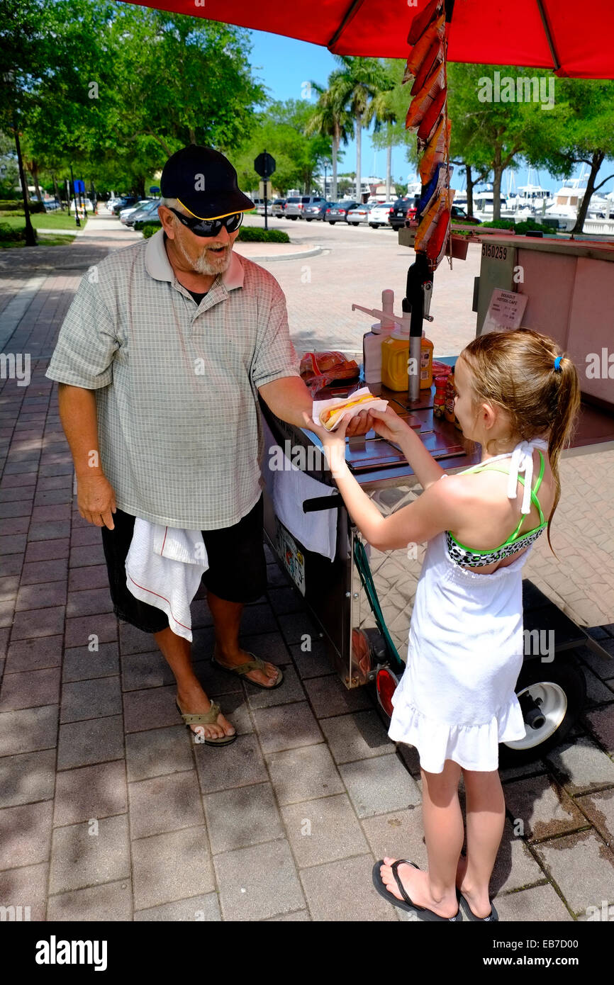 Junges Mädchen nimmt Nahrung von Hot Dog Stand mit Regenschirm Bradenton Florida Florida uns USA Stockfoto