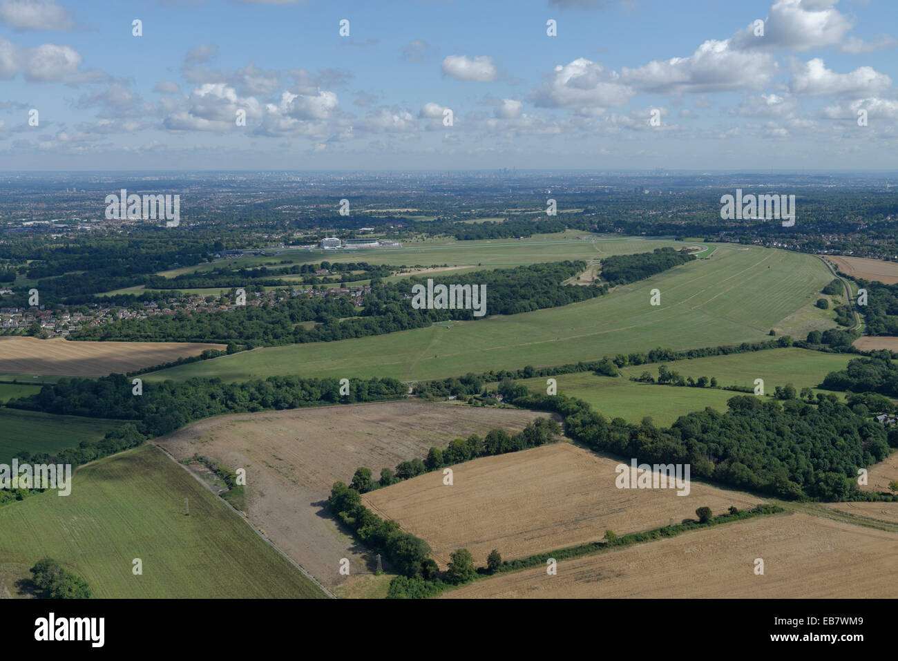 Eine Luftaufnahme von Epsom Downs mit der Rennbahn sichtbar und die Hochhäuser von London in der Ferne Stockfoto