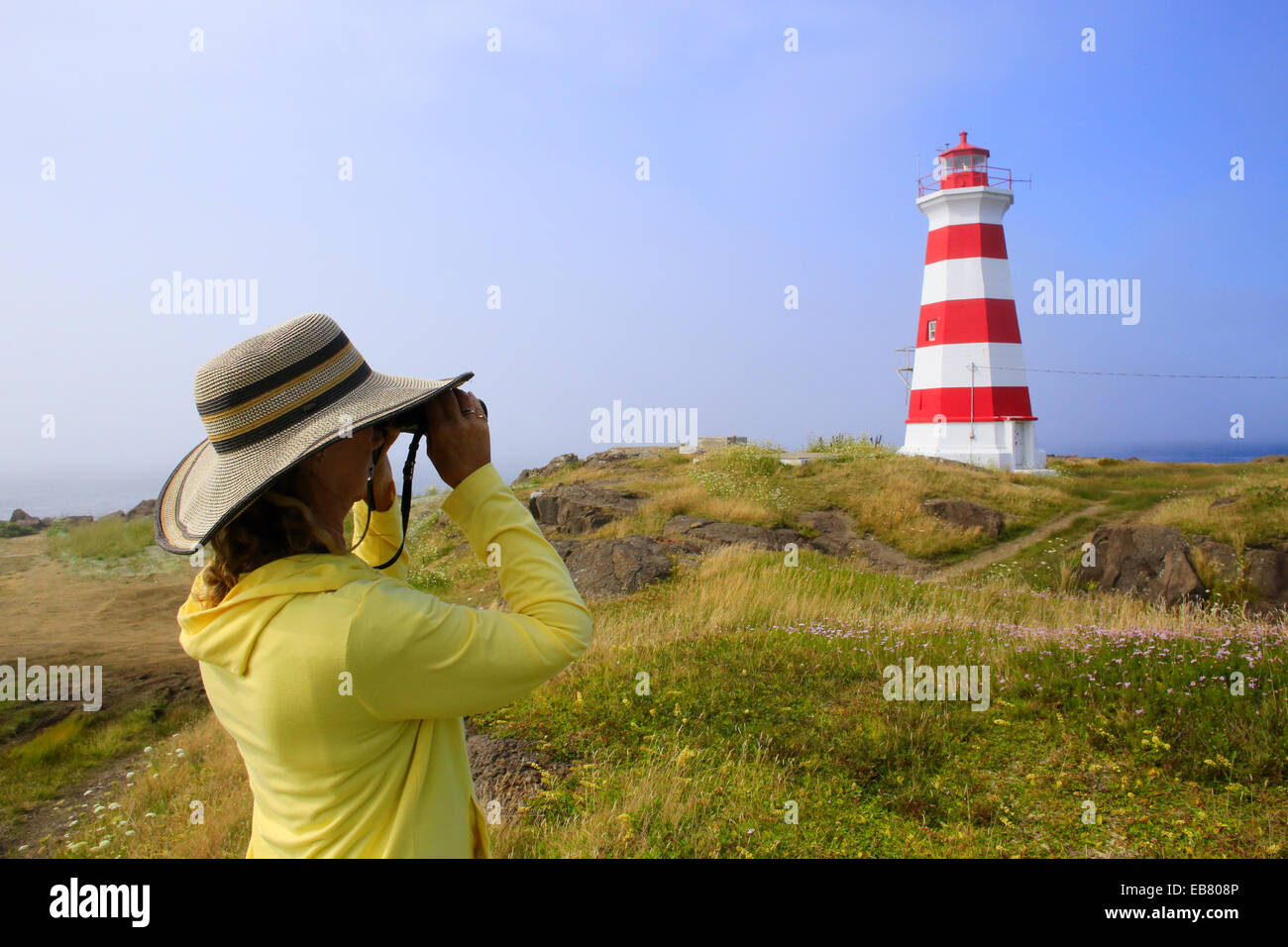 Eine Frau Die Durch Ein Fernglas In Der Nahe Von Brier Island Lighthouse In West Point Brier Island Nova Scotia Kanada Stockfotografie Alamy