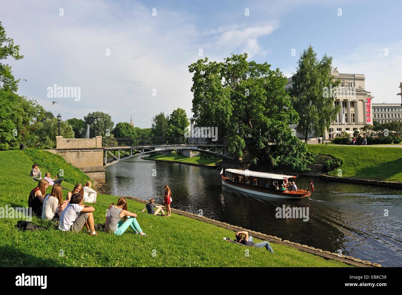 junge Menschen am Ufer des Kanals rund um die Altstadt von Riga vor der Nationaloper Haus Lettland Baltic Stockfoto