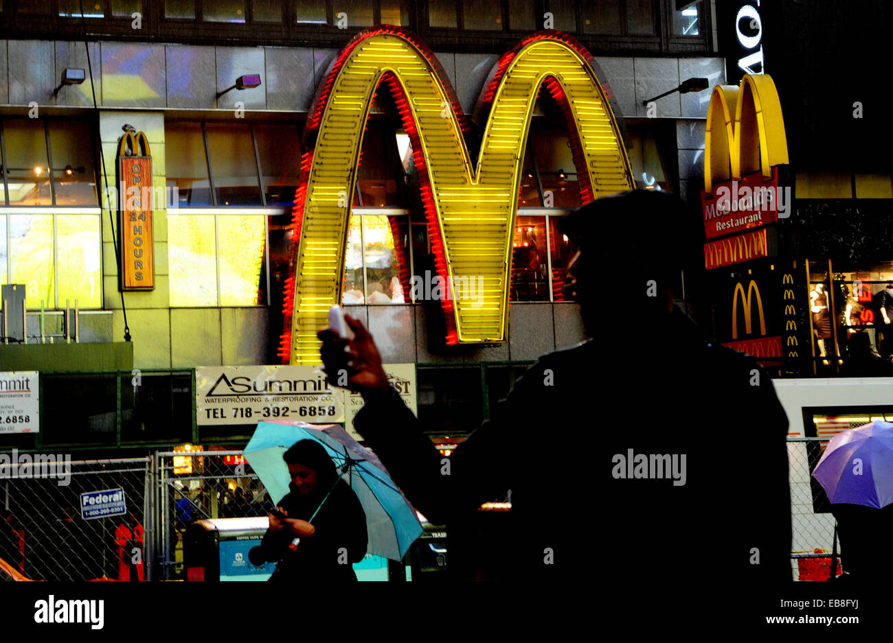 Times Square bei Nacht mit Leuten, die Benutzung von Mobiltelefonen vor McDonalds Fastfood Restaurant New York USA Stockfoto